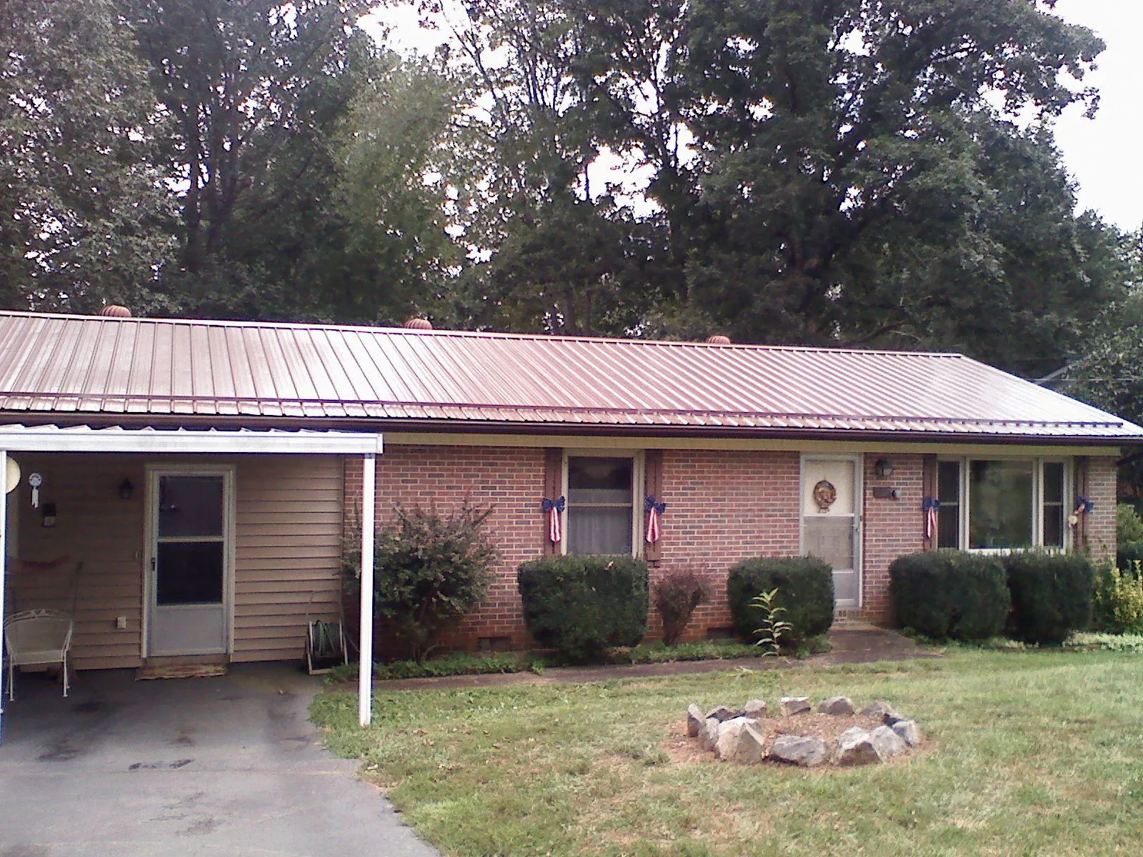 Bronze metal roof and carport on a brick ranch home — Roof Repair work by our crew in Las Animas